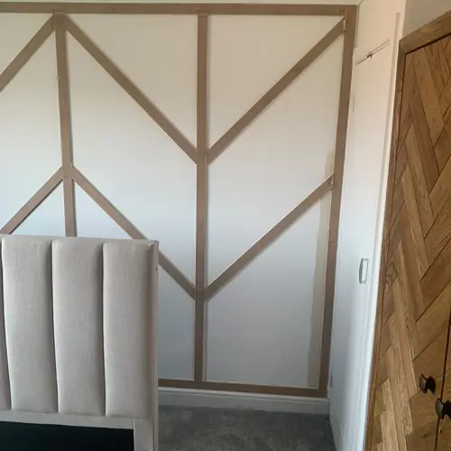 Chevron wall panelling behind an upholstered bed
