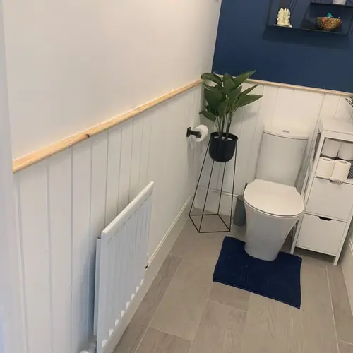 Cloakroom with tongue-and-groove panelling and a navy feature wall