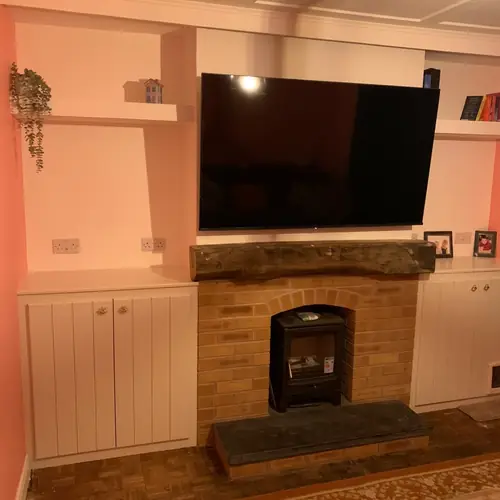 Fireplace with alcove cupboards and oak floating shelves