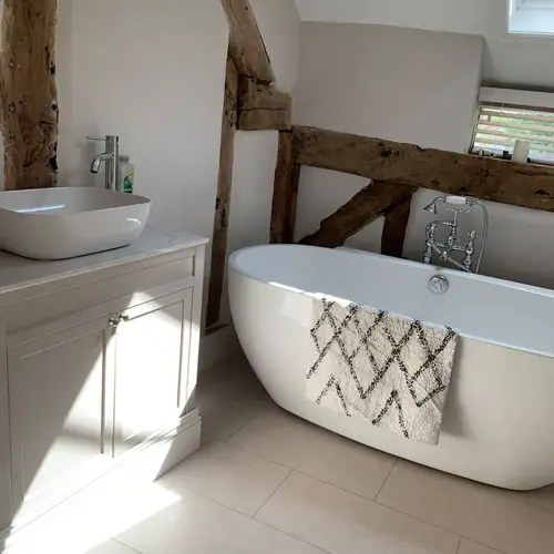 Freestanding bath and vanity unit beneath exposed oak beams