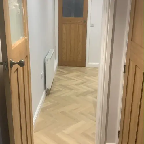 Hallway with oak internal doors and herringbone flooring