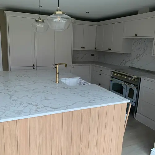 Kitchen island with a timber-panel end and quartz worktop