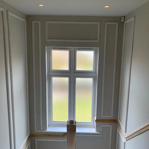 Landing with full-height wall panelling around a window