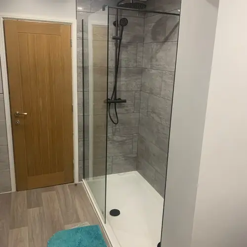 Walk-in shower enclosure next to a new oak internal door