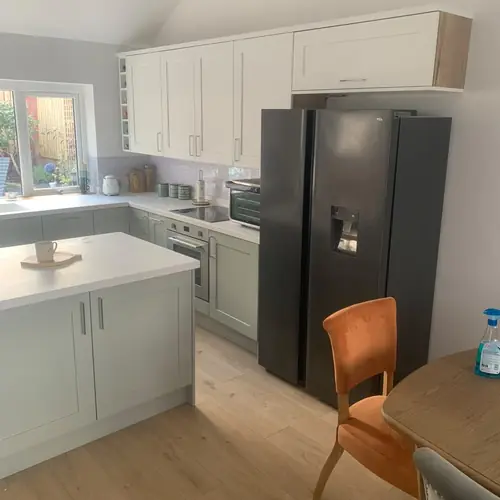 White kitchen with an island and an American-style fridge freezer