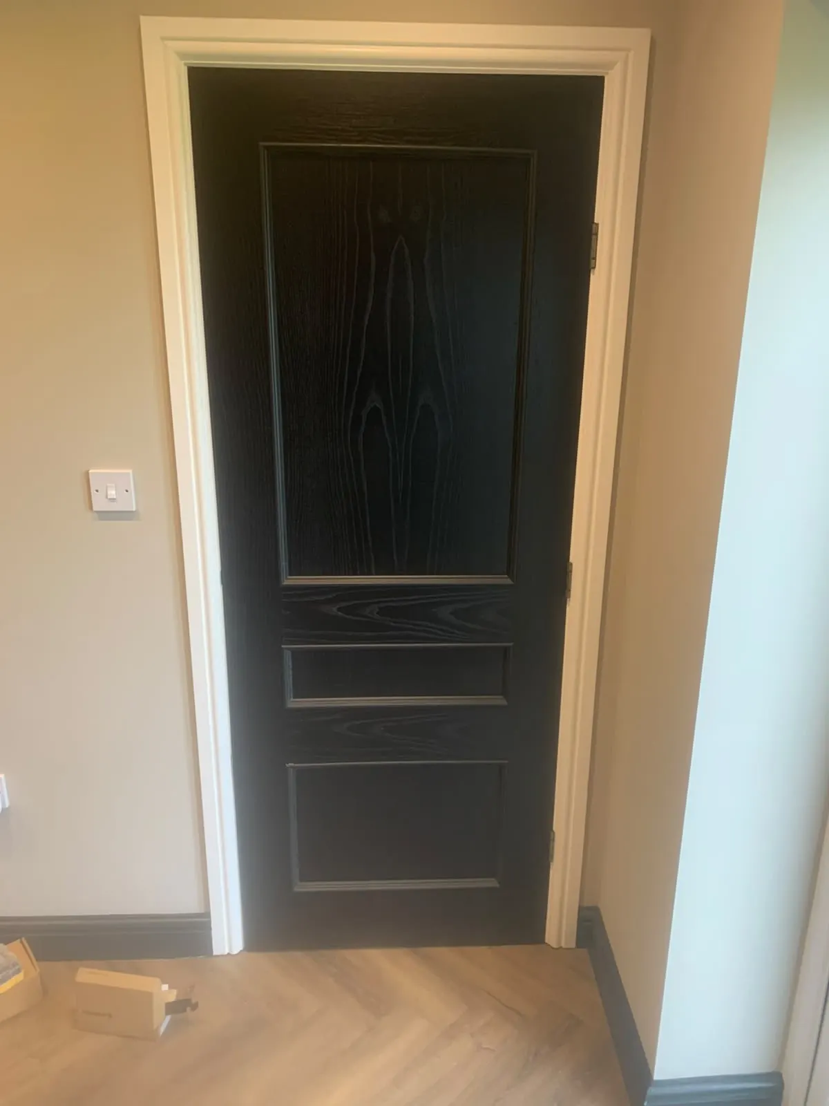 Black panelled internal door hung with new architrave