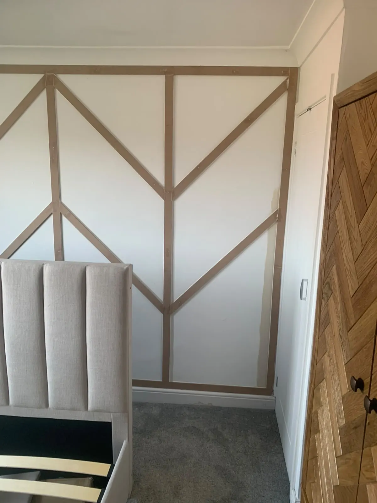 Chevron wall panelling behind a bed, made and fitted by TMC Building & Joinery