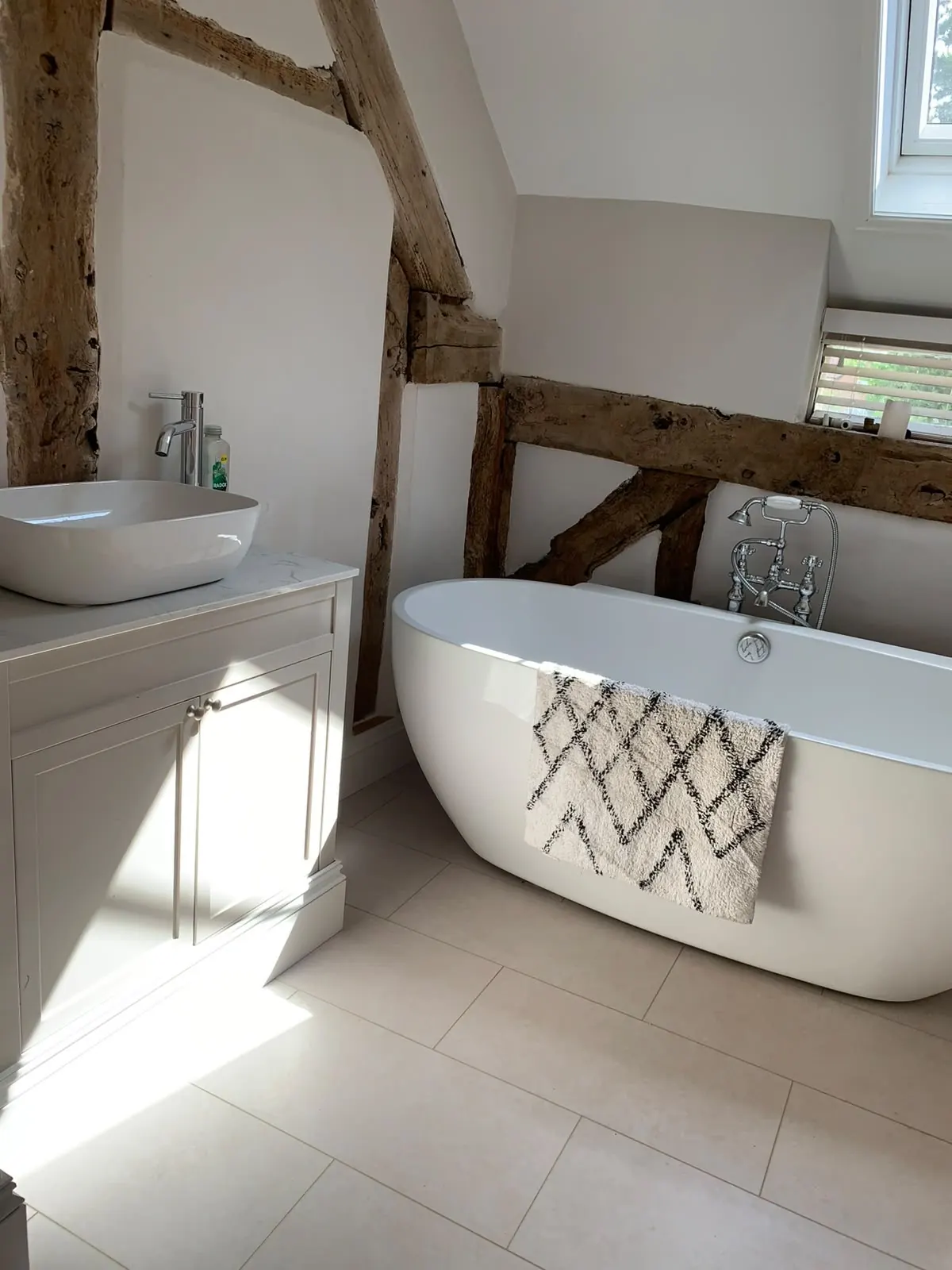 Freestanding bath beneath exposed oak beams, by TMC, joiners and builders in Cheshire and Staffordshire