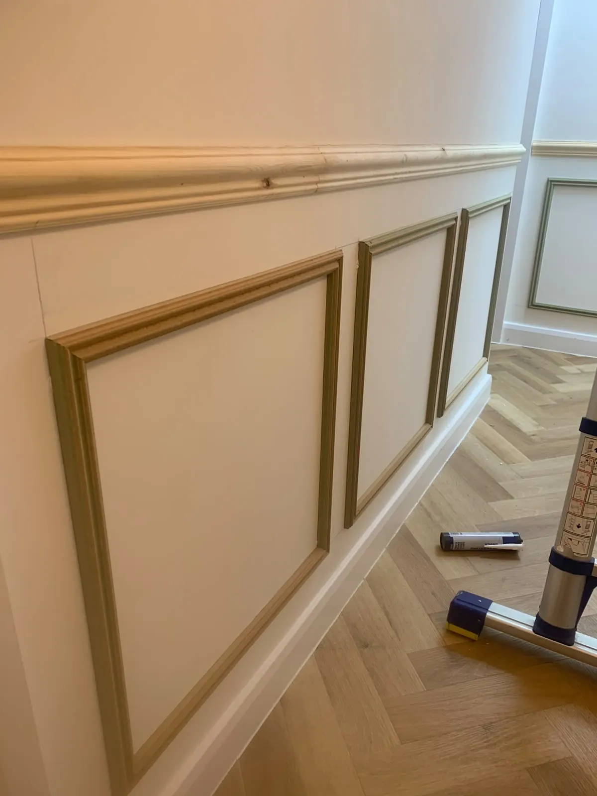 Hallway box panelling with a dado rail over herringbone flooring