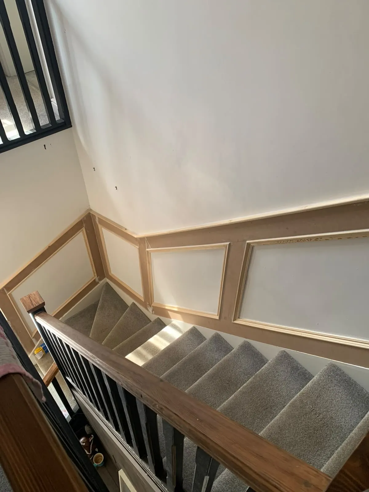 Panelled staircase wall with an oak handrail